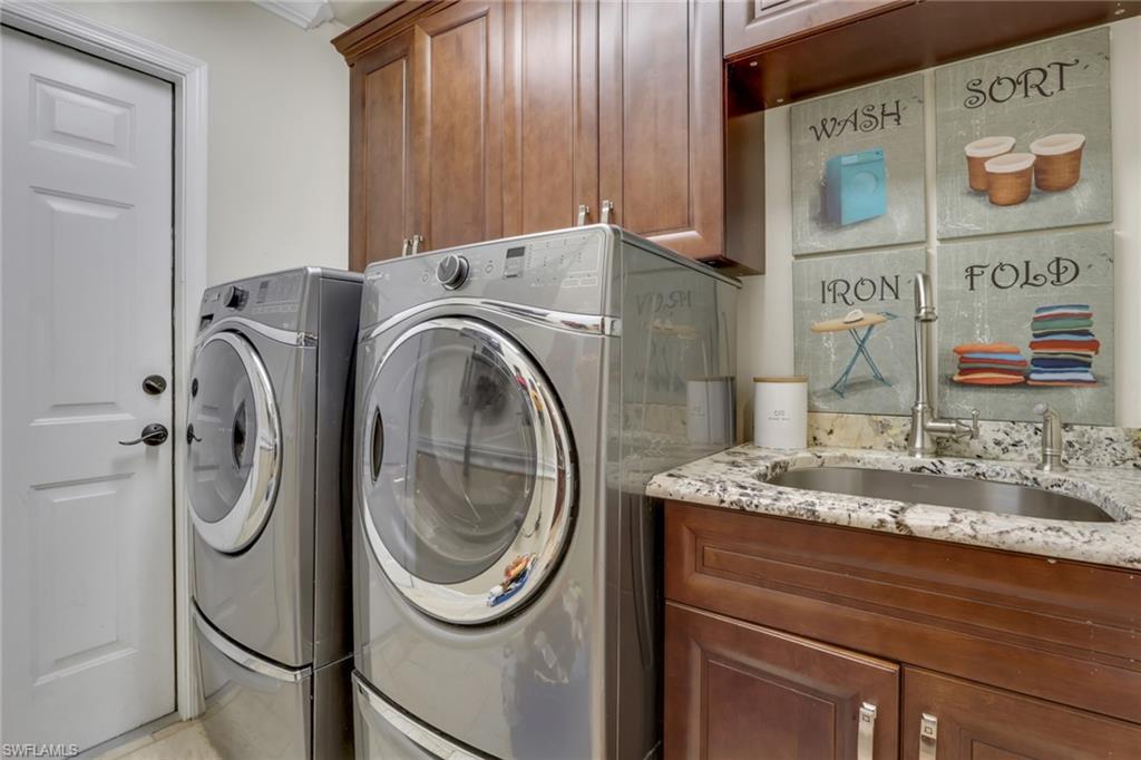 Laundry room featuring washing machine and clothes dryer and cabinet space