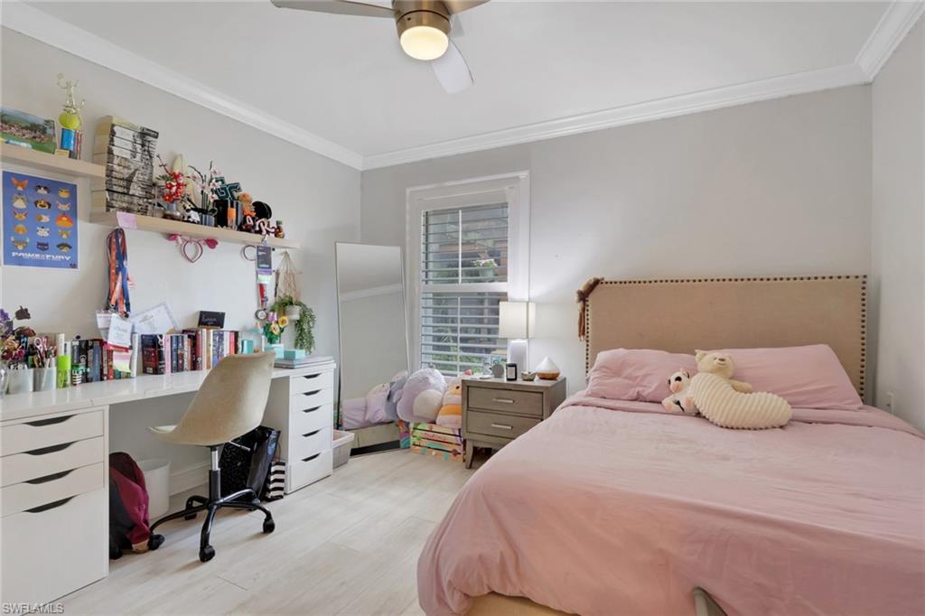 Bedroom featuring crown molding, a ceiling fan, a desk, and light wood finished floors