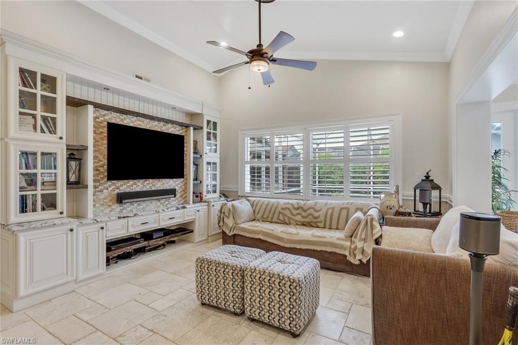 Living room with crown molding, high vaulted ceiling, stone tile flooring, a ceiling fan, and recessed lighting