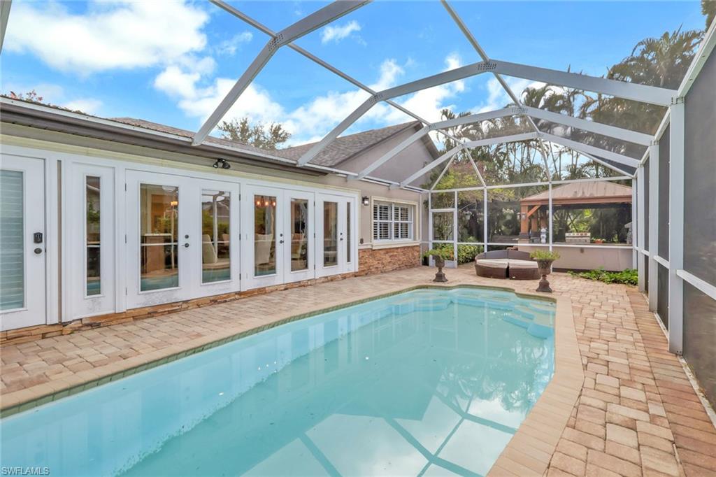 Outdoor pool featuring a sunroom, a patio area, a lanai, and french doors