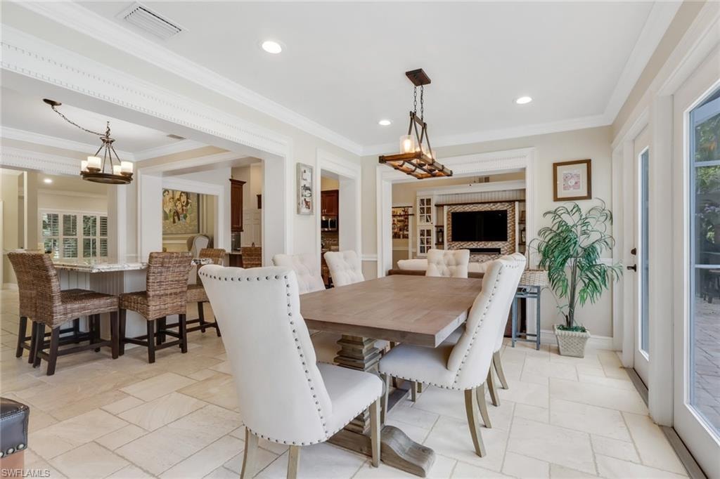 Dining space featuring ornamental molding, recessed lighting, and a chandelier