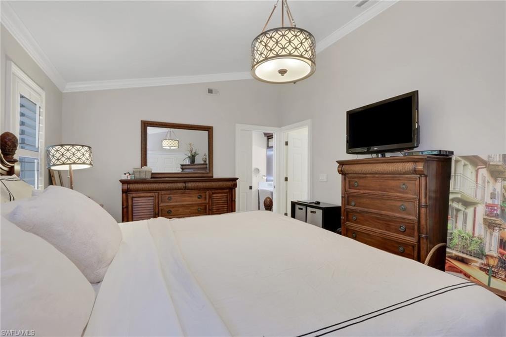 Bedroom with ornamental molding and vaulted ceiling