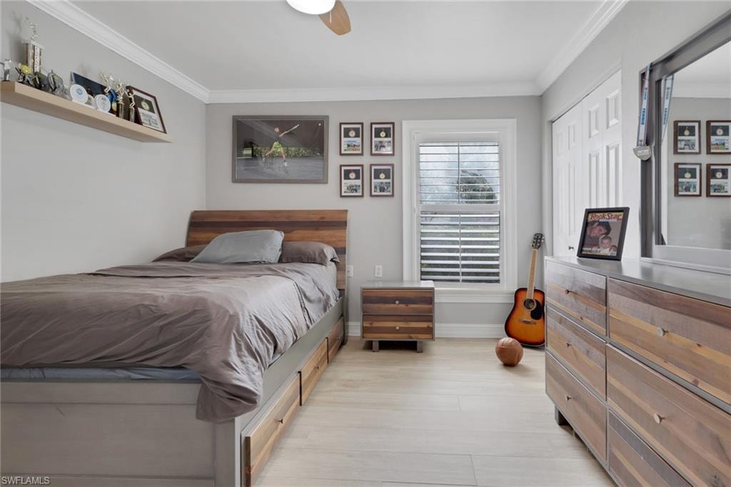 Bedroom featuring crown molding, a ceiling fan, and light wood-type flooring