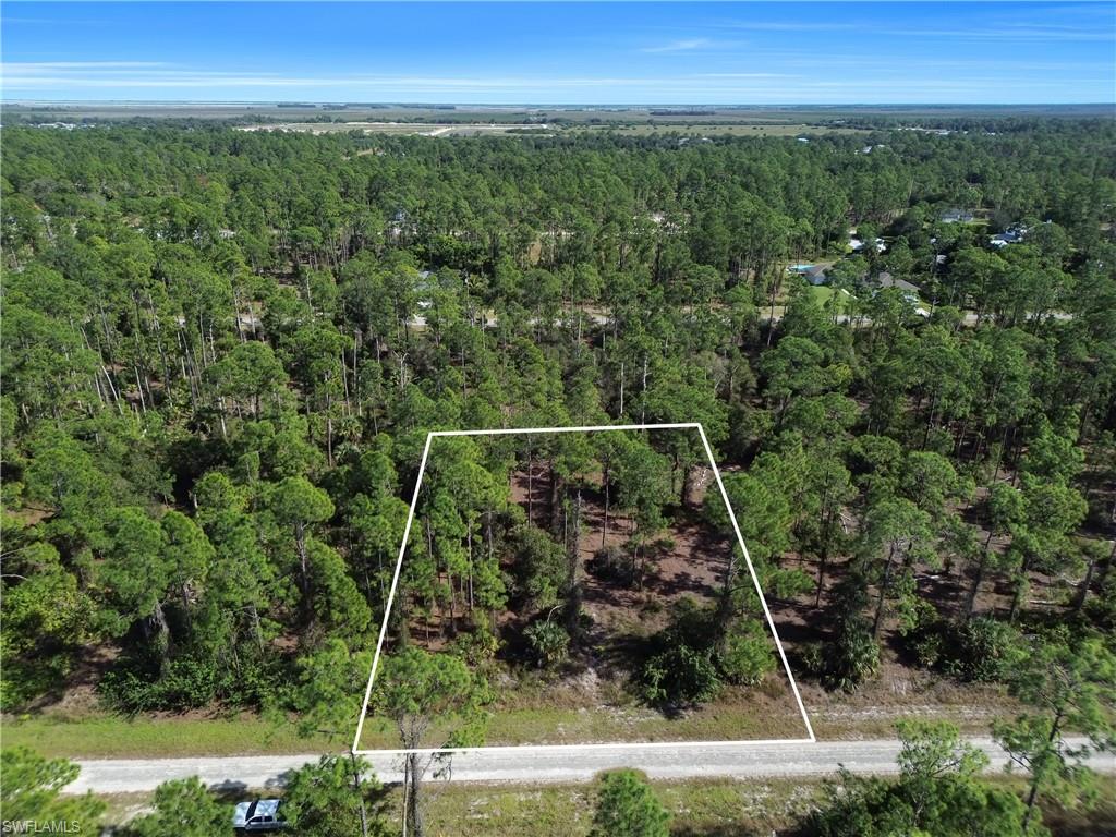 Aerial view of property and surrounding area with property parcel outlined