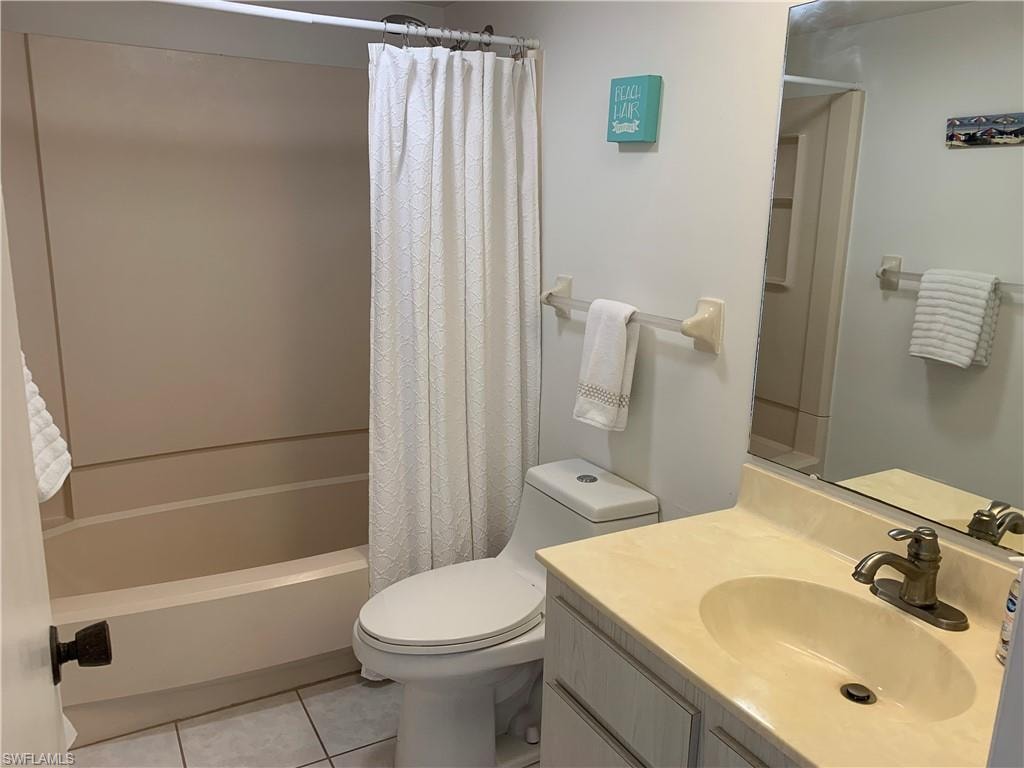 Full bathroom featuring tile patterned floors, vanity, shower / bath combination with curtain, and toilet