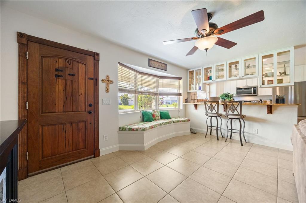 Entryway with light tile patterned floors and a ceiling fan