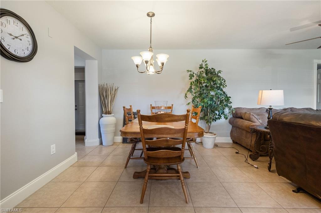 Dining room with light tile patterned flooring and a chandelier