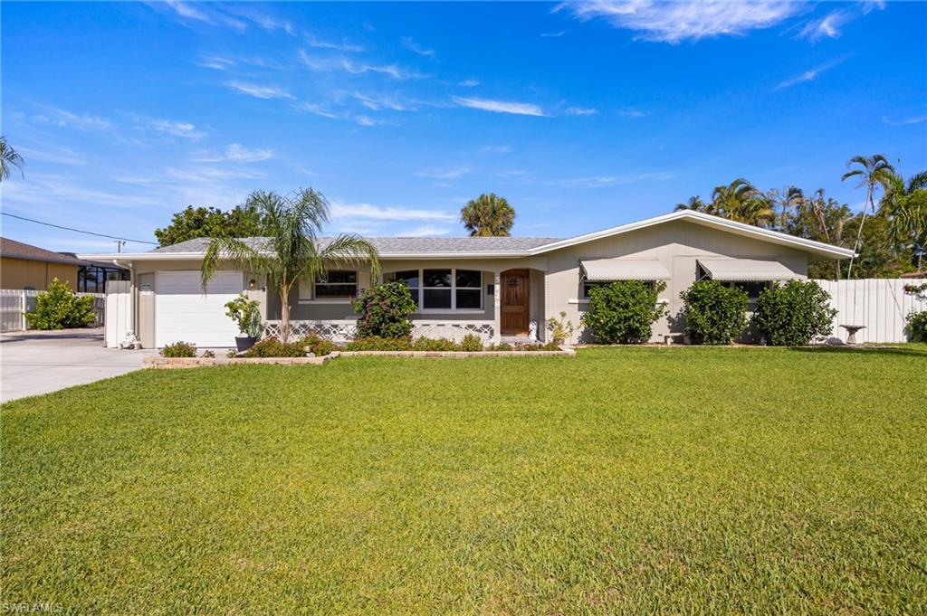Single story home featuring a garage and concrete driveway