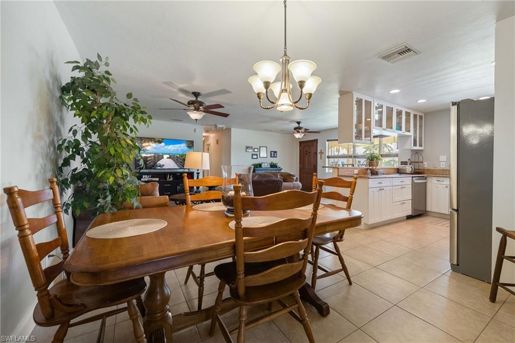 Dining room featuring a chandelier, light tile patterned floors, a ceiling fan, and recessed lighting