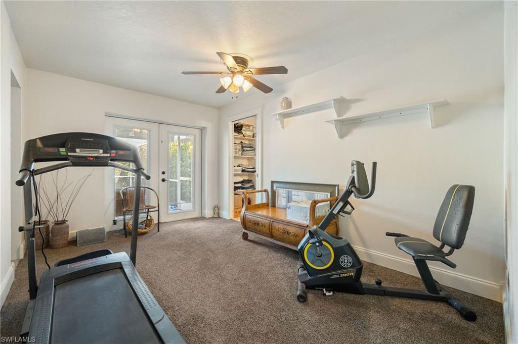 Workout area with carpet flooring, ceiling fan, and french doors