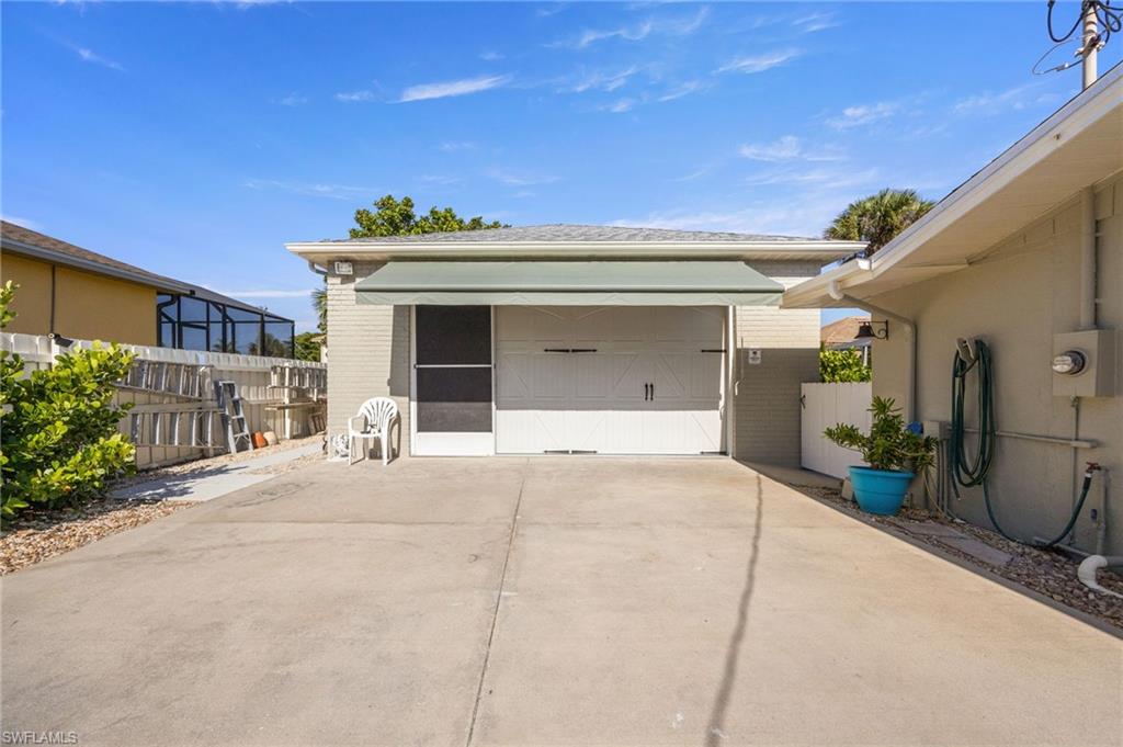 Detached garage featuring concrete driveway