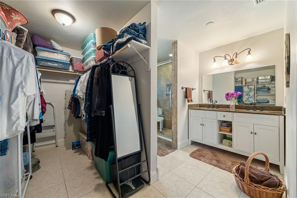 Walk in closet with light tile patterned floors