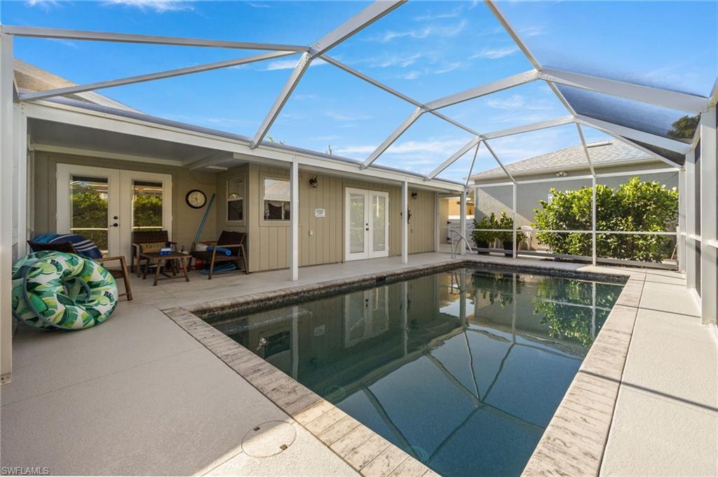 Outdoor pool featuring french doors, a lanai, a sunroom, and a patio area