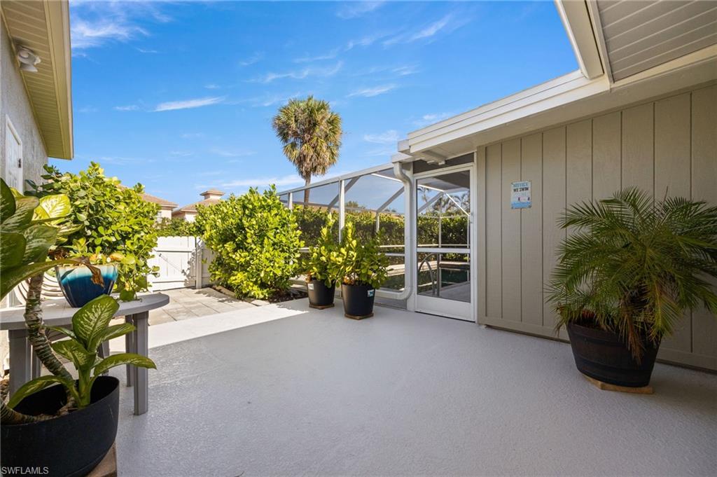 View of patio featuring a lanai, a sunroom, and a gate