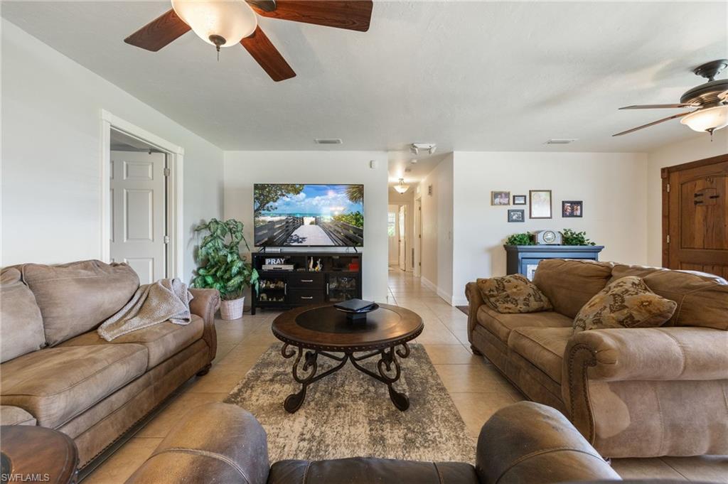 Living room with ceiling fan and tile patterned floors