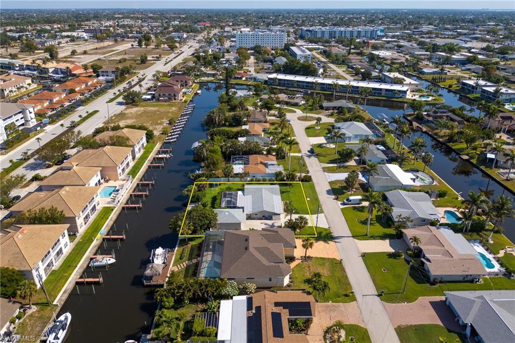 Aerial view of property and surrounding area featuring a large body of water and nearby suburban area