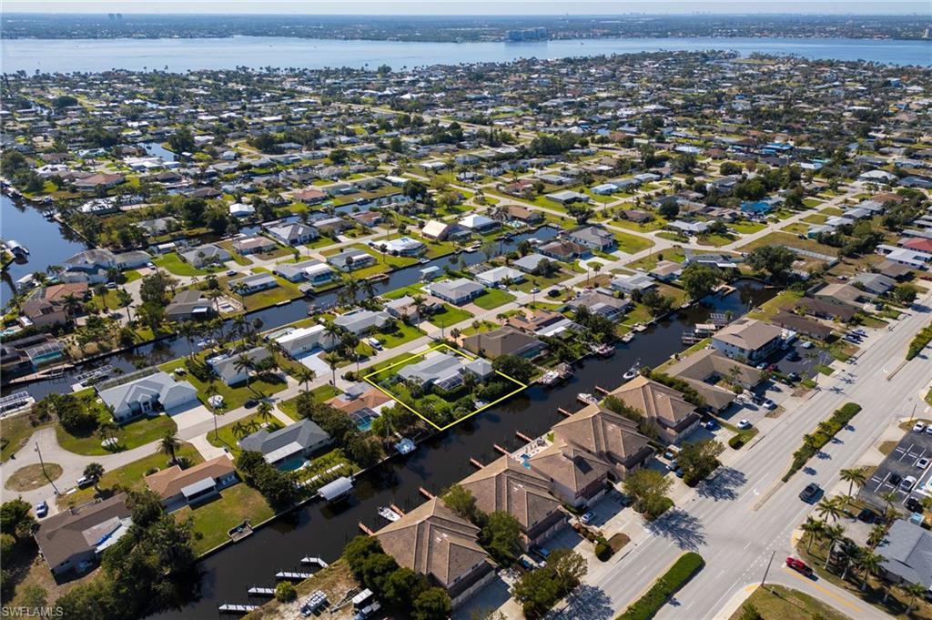Aerial view of property's location with a large body of water and nearby suburban area