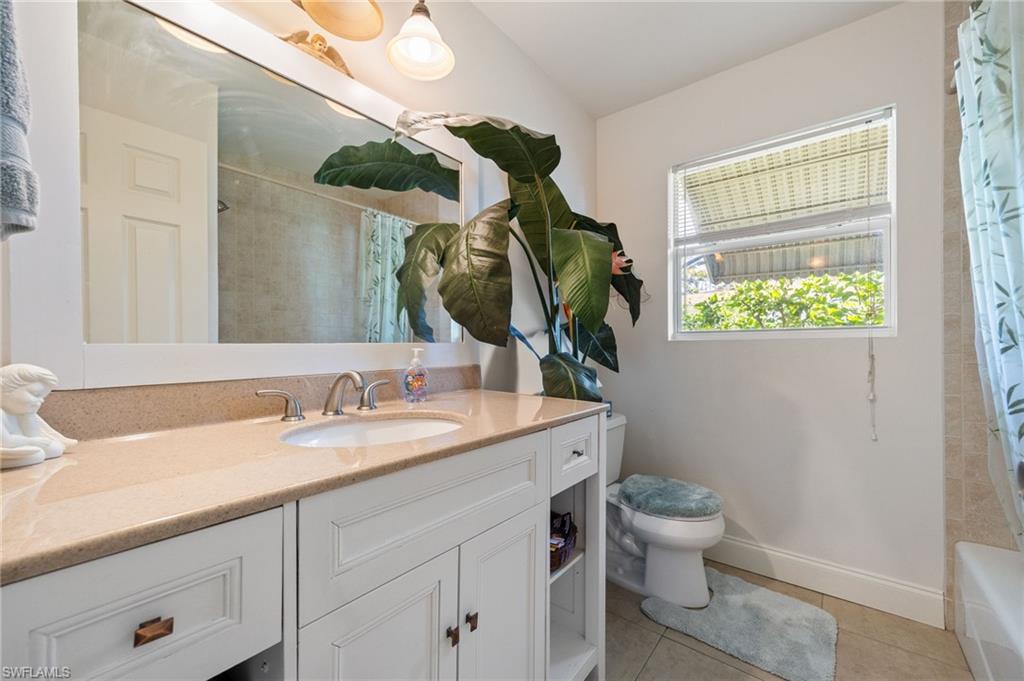 Full bath with light tile patterned flooring, vanity, and shower / bath combination with curtain