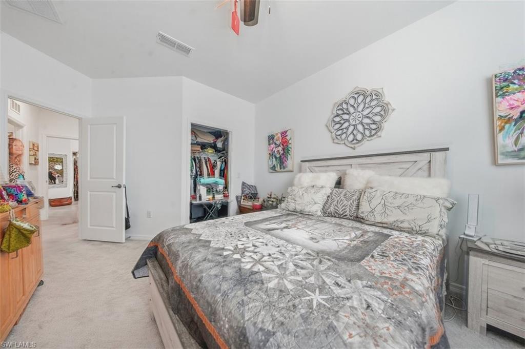 Bedroom with light colored carpet and a closet