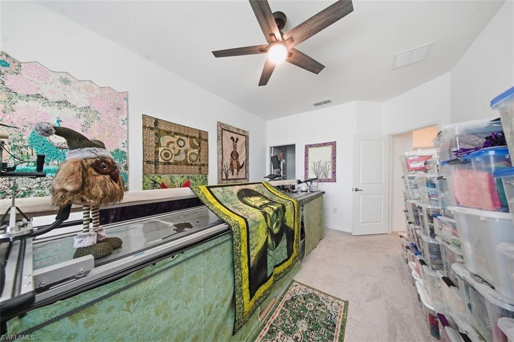 Bedroom with light carpet and a ceiling fan