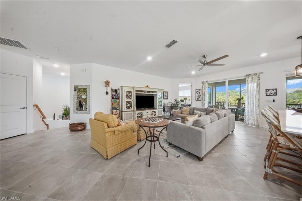 Tiled living area with recessed lighting and a ceiling fan