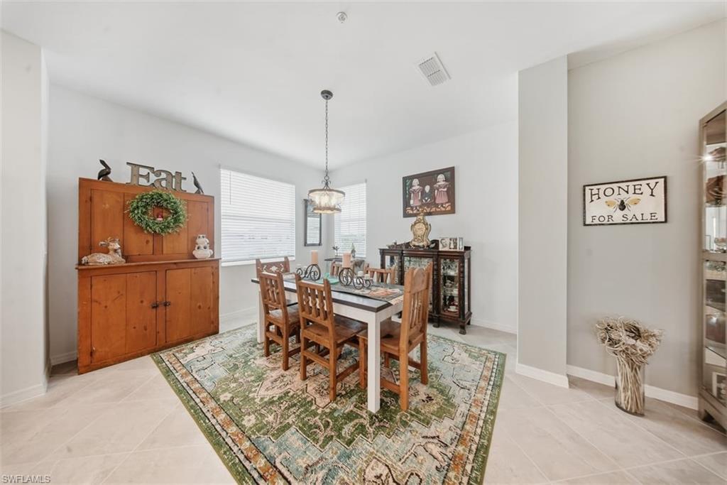 Dining space with light tile patterned floors and a chandelier