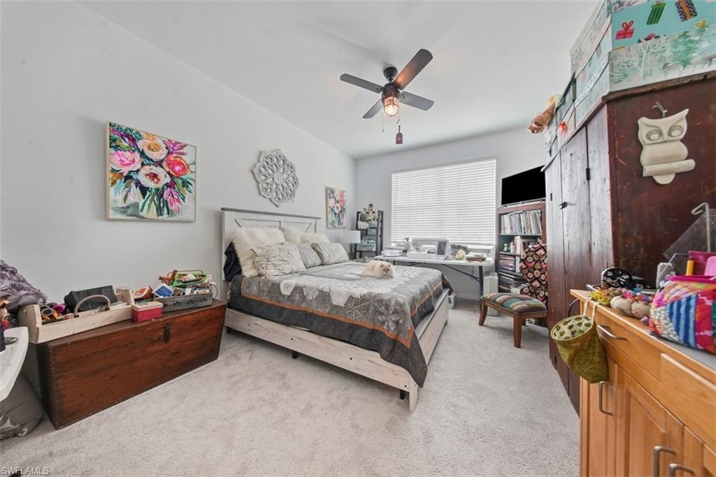 Bedroom featuring light carpet and a ceiling fan