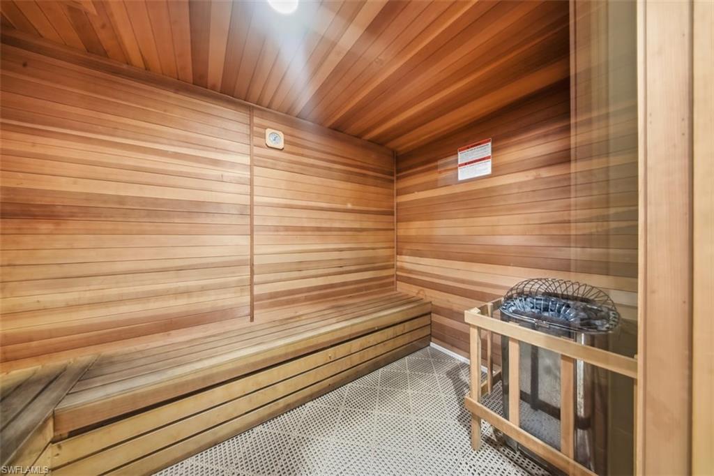 Relaxing sauna with tile patterned floors, wooden walls, and wood ceiling