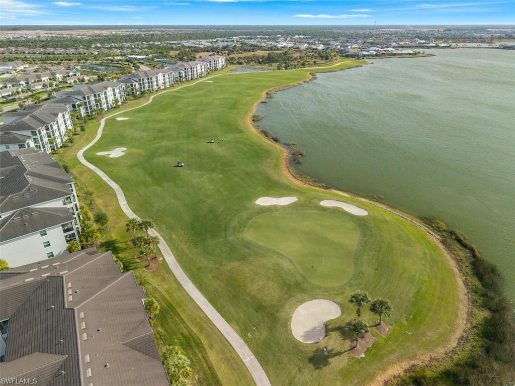 Aerial view of property and surrounding area with a large body of water and a golf course