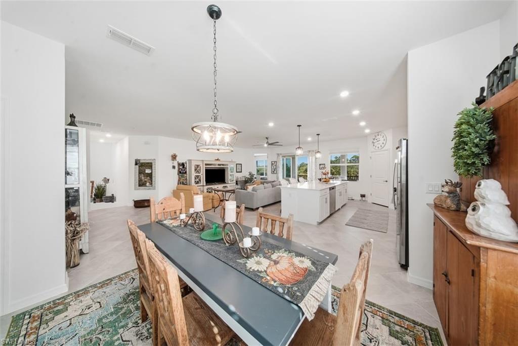 Dining space featuring recessed lighting, a ceiling fan, a chandelier, and light tile patterned floors
