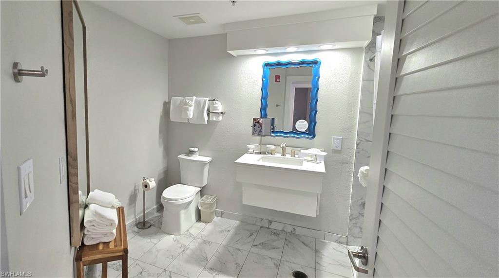 Bathroom with vanity and light marble finish floors