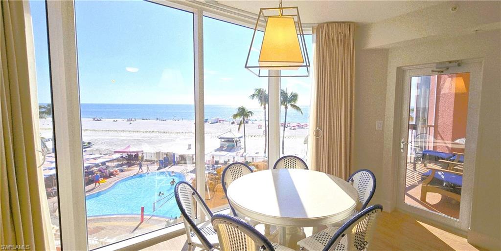 Dining area featuring view of water and beach and wood finished floors