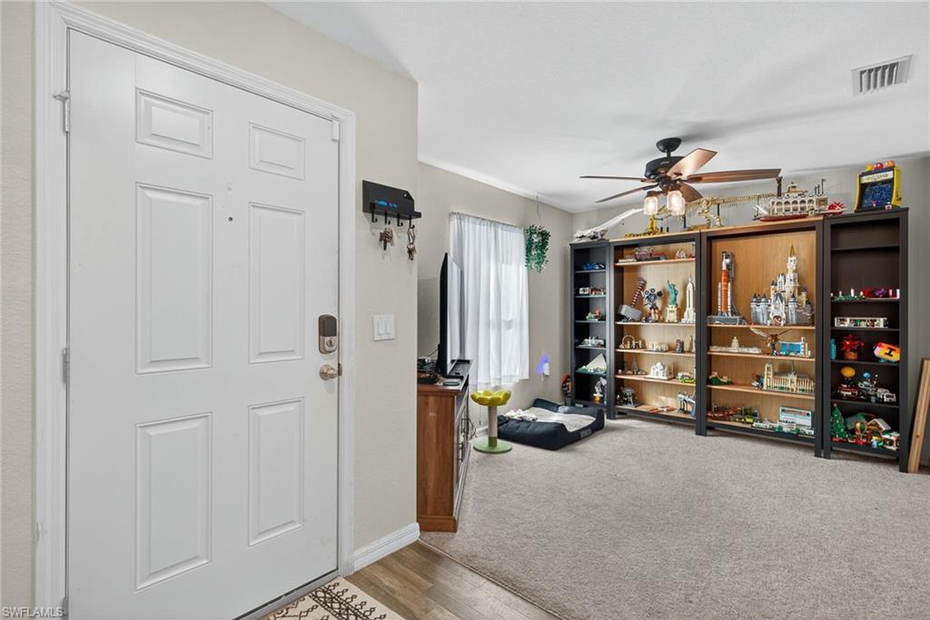 Foyer entrance featuring wood finished floors, a ceiling fan, and carpet floors