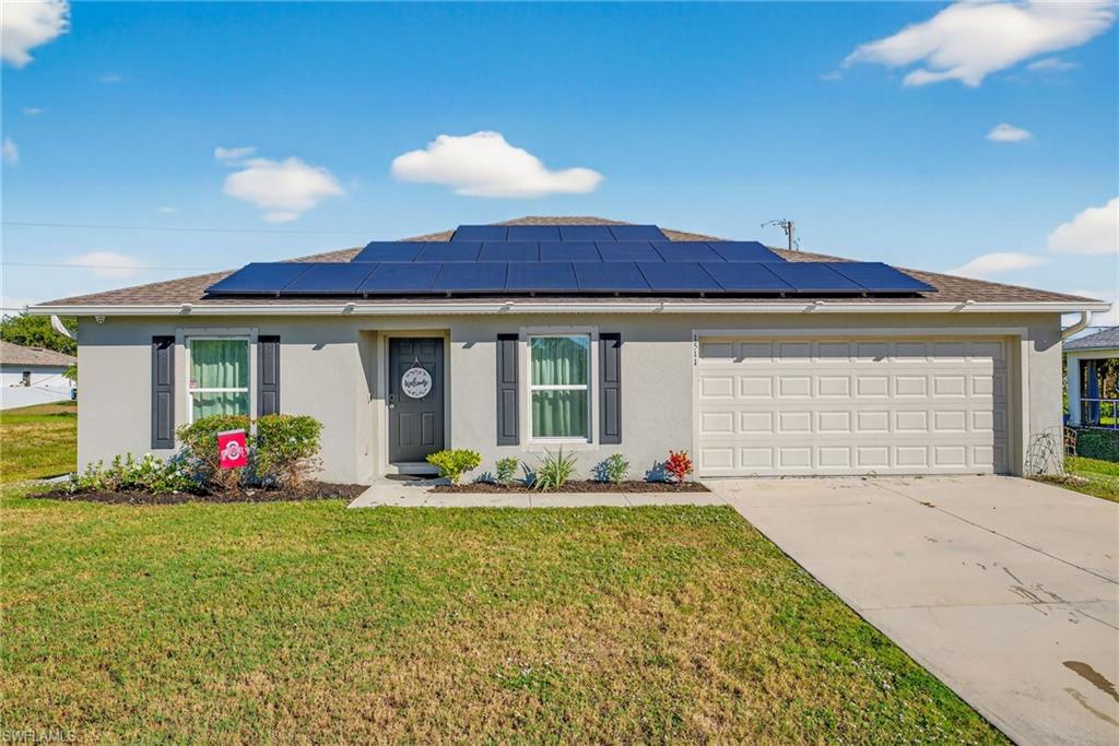 Ranch-style house with stucco siding, a front yard, driveway, and a garage