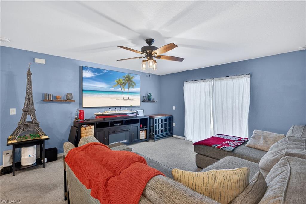 Living area with carpet and ceiling fan