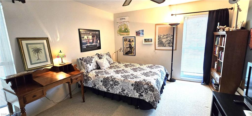 Carpeted bedroom featuring access to exterior and ceiling fan