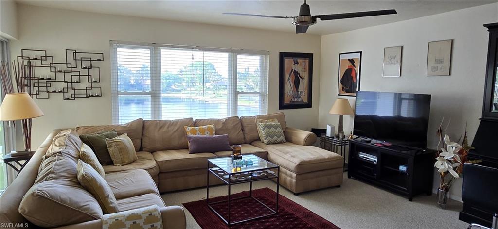 Carpeted living room featuring ceiling fan