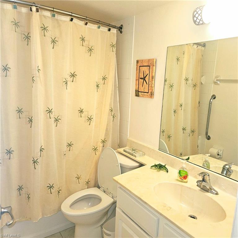 Bathroom with vanity, shower / bath combination with curtain, and tile patterned flooring