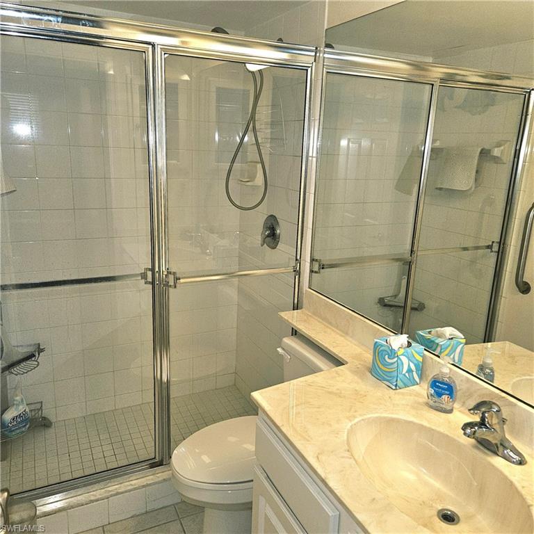 Full bathroom featuring vanity, tile patterned flooring, and a shower stall