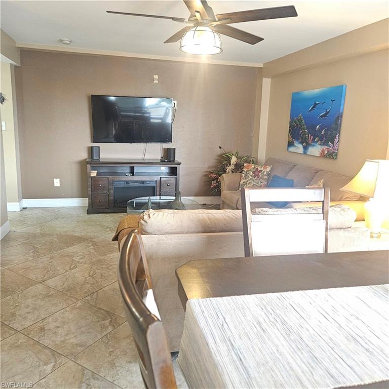 Living room featuring a ceiling fan and crown molding