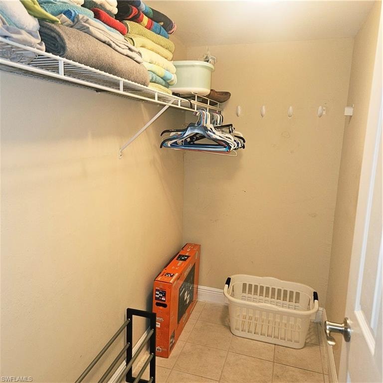 Spacious closet with light tile patterned floors