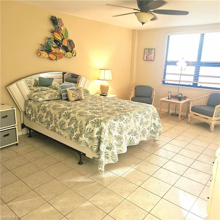 Bedroom with light tile patterned floors and a ceiling fan