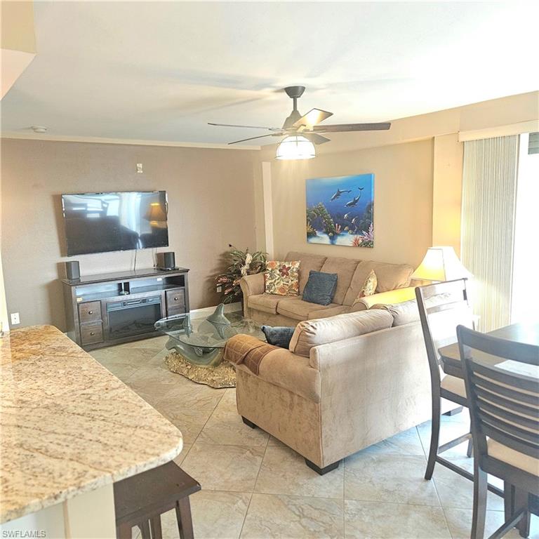 Living room with ceiling fan and light tile patterned flooring