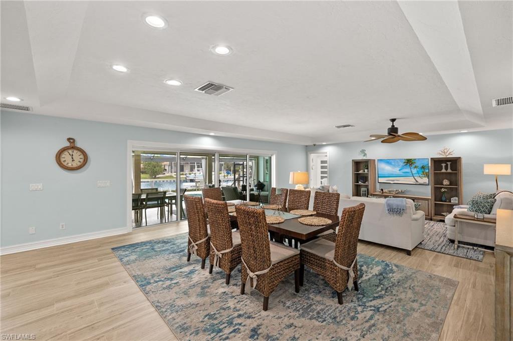 Dining space with recessed lighting, a raised ceiling, light wood-style floors, and ceiling fan