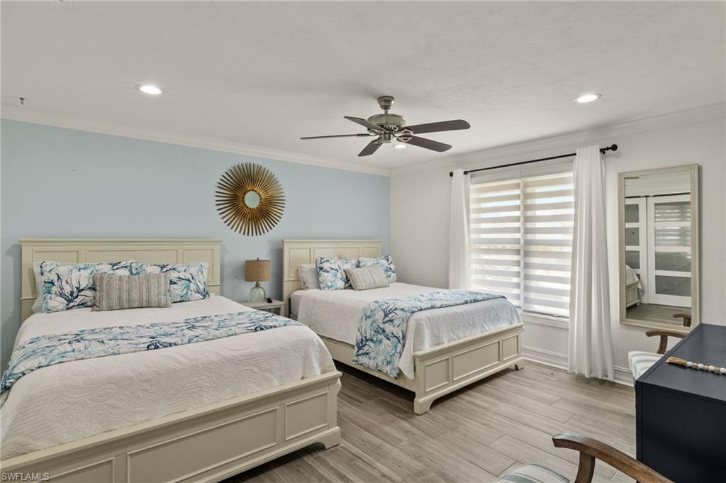 Bedroom with crown molding, light wood-type flooring, a ceiling fan, and recessed lighting
