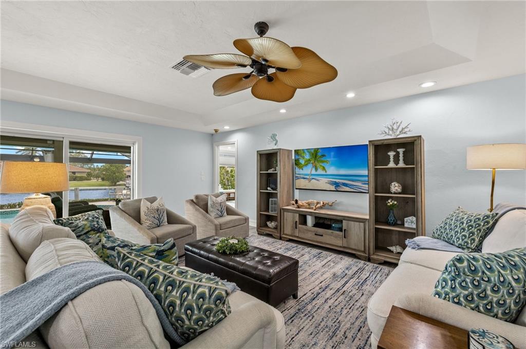 Living area featuring recessed lighting, a raised ceiling, and ceiling fan