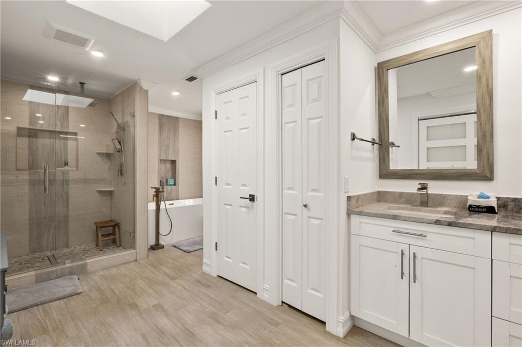 Full bath with vanity, a freestanding bath, a closet, a stall shower, and recessed lighting