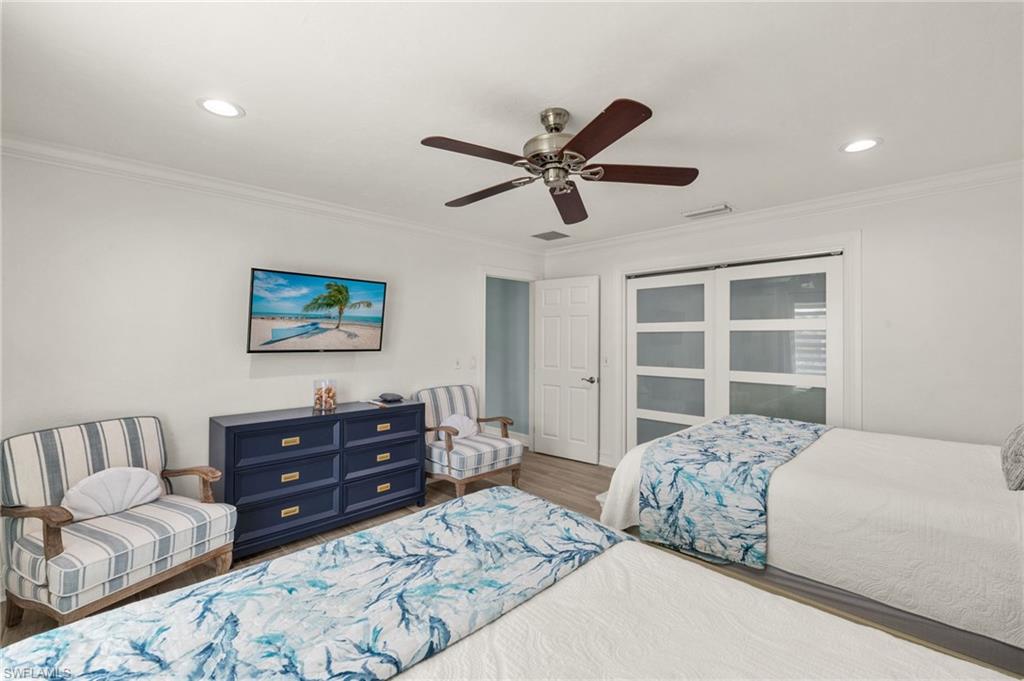 Bedroom with ornamental molding, ceiling fan, recessed lighting, and wood finished floors