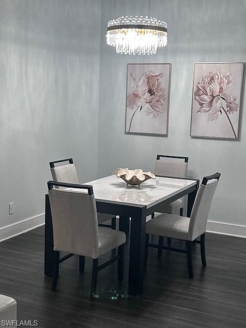 Dining area with dark wood-type flooring and a chandelier