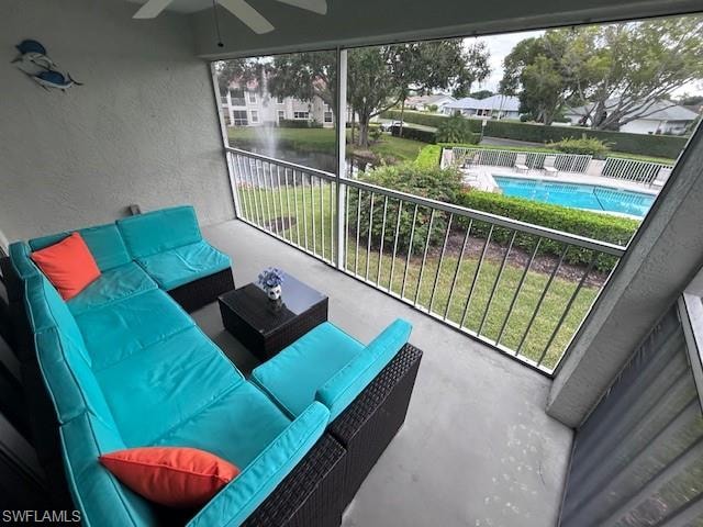 Balcony with ceiling fan, an outdoor living space, and view of pool area